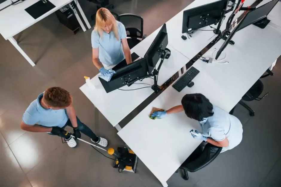 Equipe realizando limpeza e organização em escritório, ilustrando atividades práticas de gestão de facilities no ambiente corporativo.