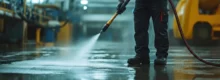 Limpeza com hidrojateamento industrial sendo realizada em piso de fábrica com alta pressão de água
